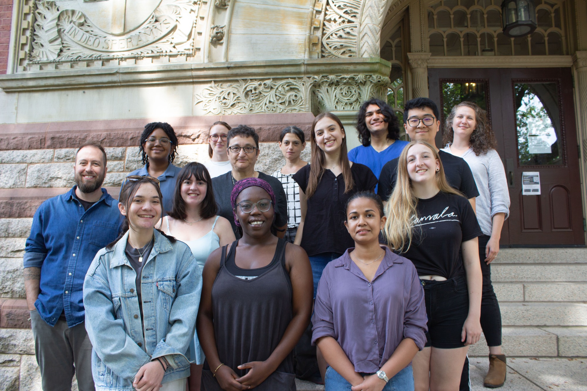 A group of people standing on a set of stairs smiling.