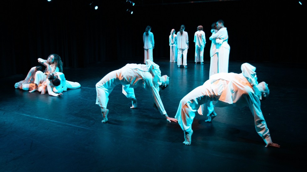 Groups of dancers in various poses on a stage