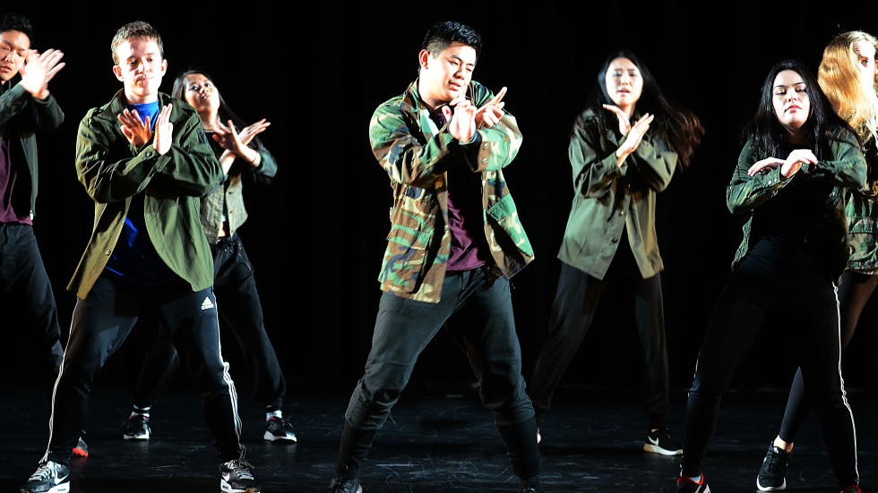 A group of dancers with their arms crossed in front of them 