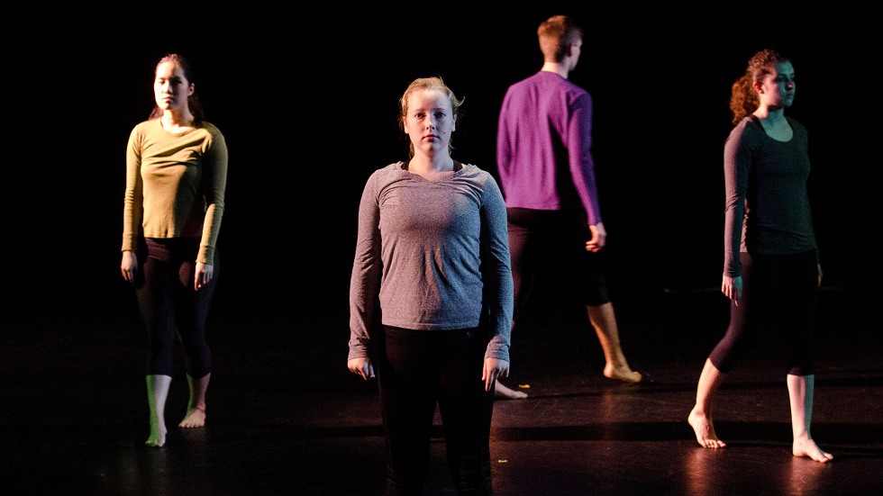 A group of dancers standing in various places on a stage