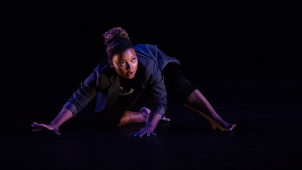 A female dancer crouching on the floor 