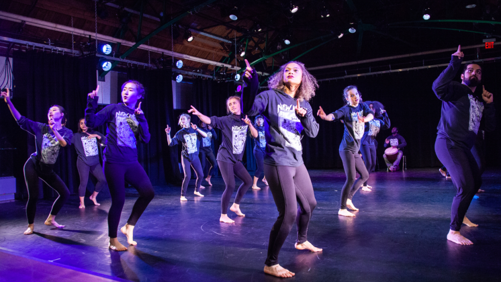 A group of dancers dancing with their fingers pointed 