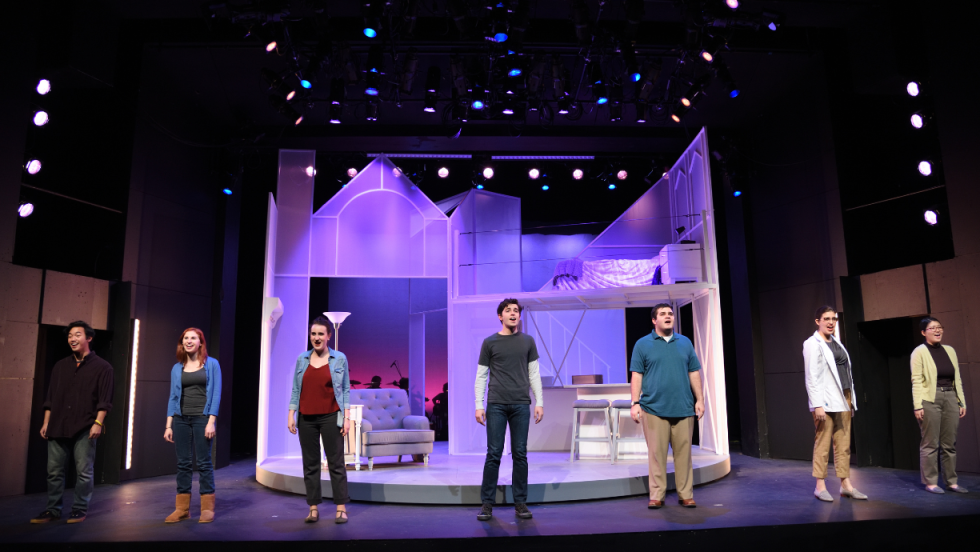 7 people standing onstage, facing the audience