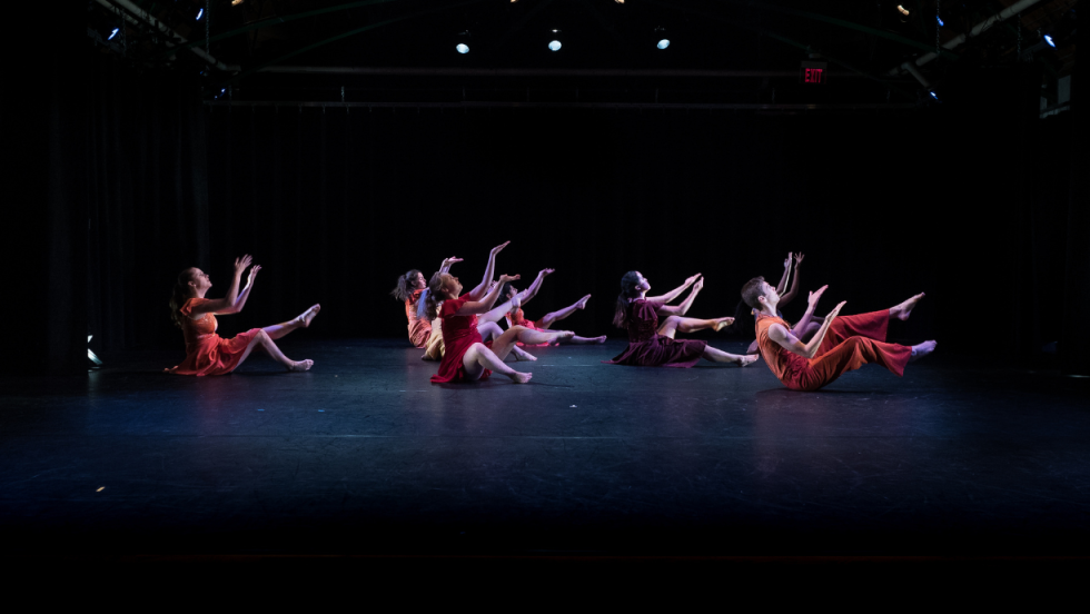 Dancers on the floor with their legs and arms up 